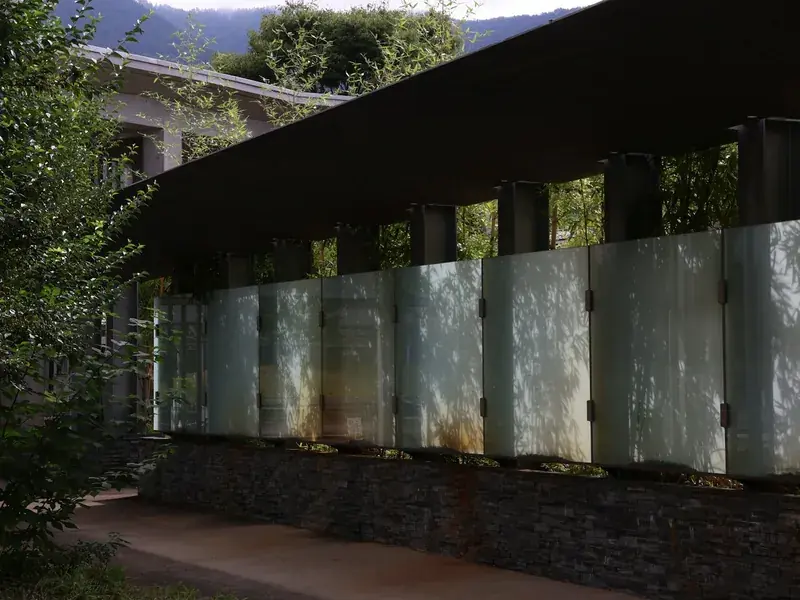 Opal perspex-style privacy screen panels along a garden wall