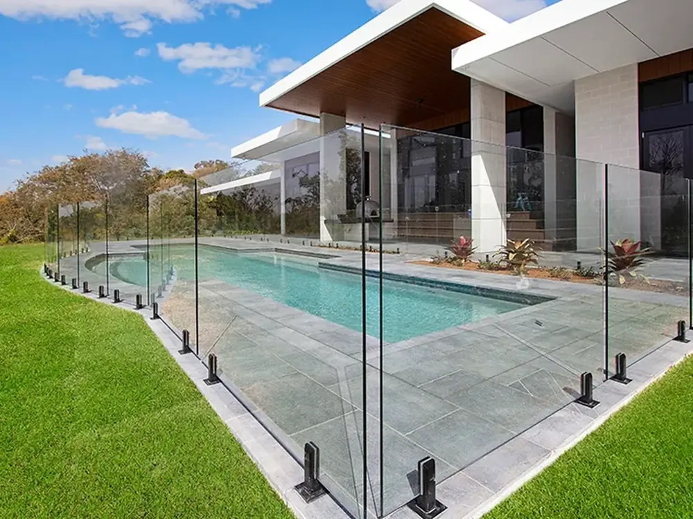 Frameless glass pool fence around a modern in-ground pool, compliant with Victorian pool safety rules